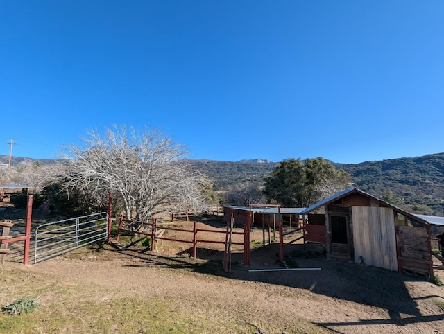 view of yard featuring an outbuilding, a mountain view, and a rural view