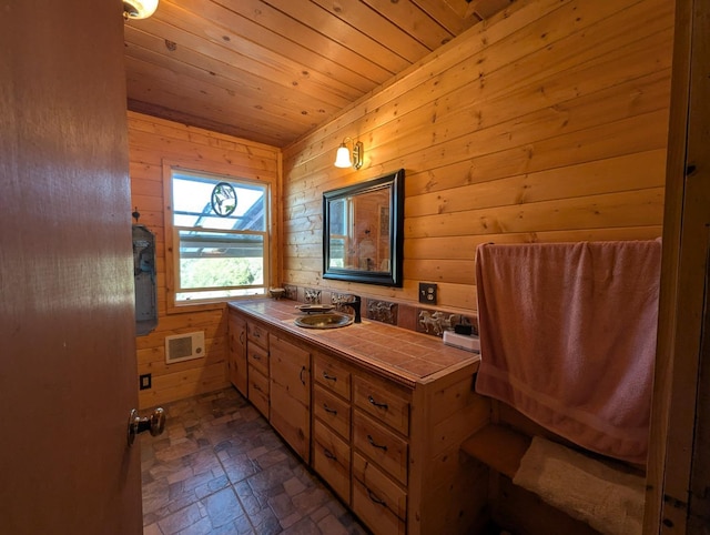 bathroom featuring vanity, wood ceiling, and wood walls