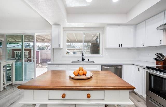 kitchen with stainless steel appliances, sink, white cabinets, and light wood-type flooring