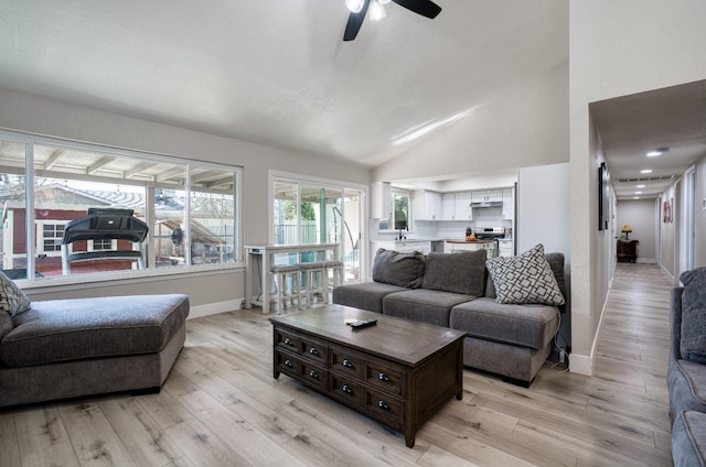 living room with ceiling fan, lofted ceiling, and light wood-type flooring