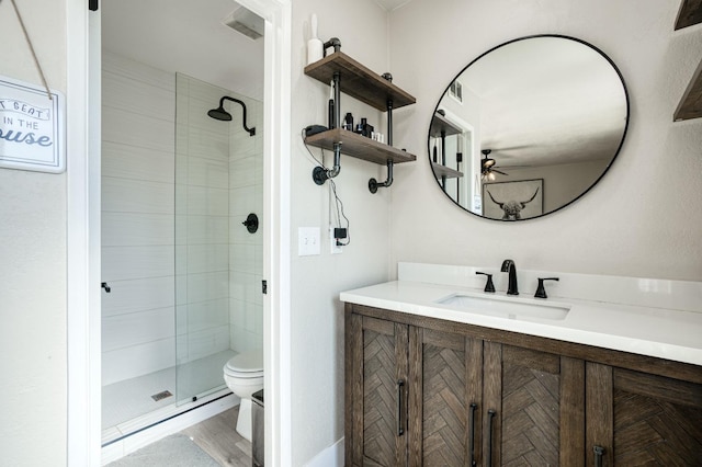 bathroom with vanity, a shower with shower door, and toilet