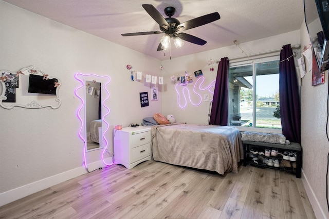 bedroom with light wood-type flooring, a textured ceiling, and ceiling fan