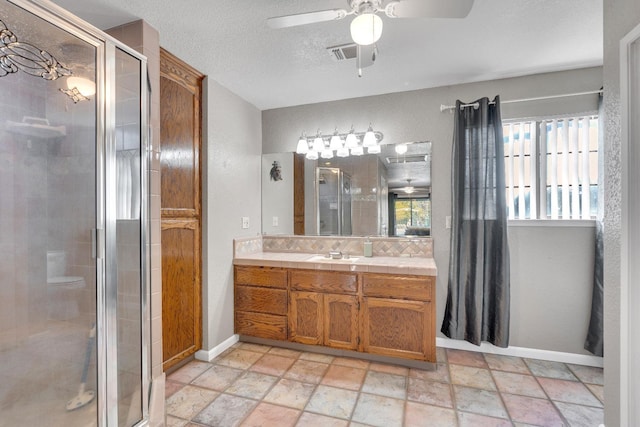 bathroom featuring vanity, plenty of natural light, a shower with shower door, and a textured ceiling