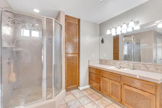 bathroom featuring vanity, an enclosed shower, and decorative backsplash