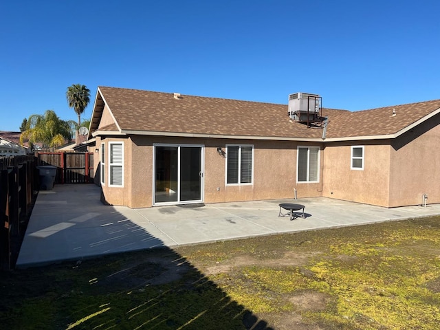 back of property featuring a patio, roof with shingles, fence, and stucco siding