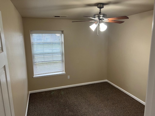 empty room with ceiling fan, carpet floors, visible vents, and baseboards