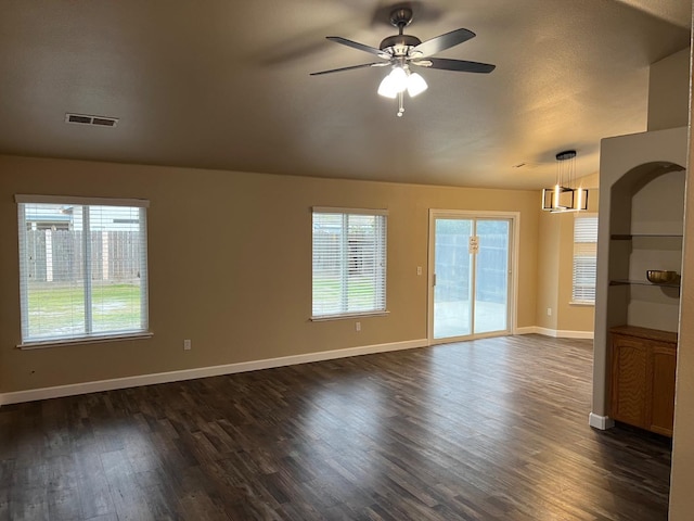 spare room with dark wood-style floors, visible vents, baseboards, and a ceiling fan