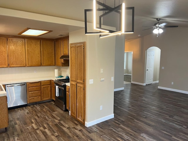 kitchen featuring arched walkways, brown cabinets, stainless steel appliances, decorative backsplash, and dark wood-type flooring