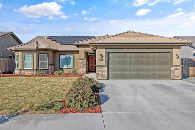 view of front of home featuring a garage, a front lawn, and solar panels