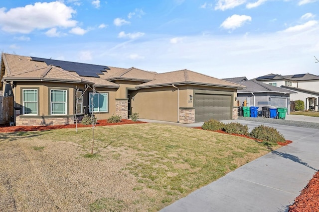 prairie-style house featuring a garage, a front lawn, and solar panels