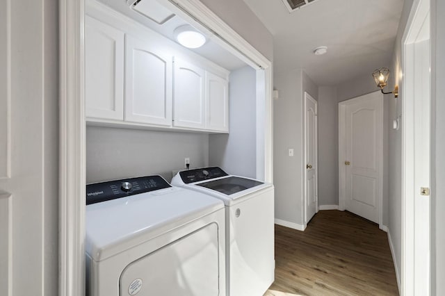 laundry area featuring independent washer and dryer, light hardwood / wood-style flooring, and cabinets