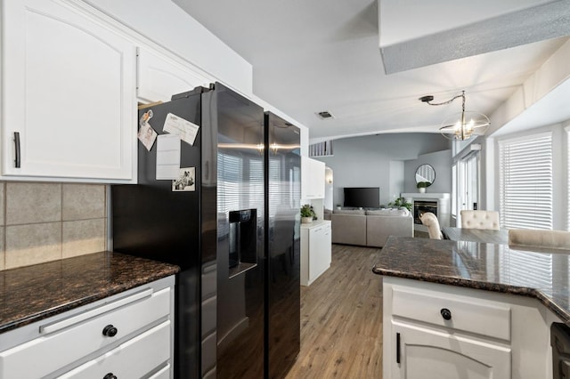 kitchen featuring white cabinetry, light hardwood / wood-style floors, stainless steel fridge with ice dispenser, and backsplash