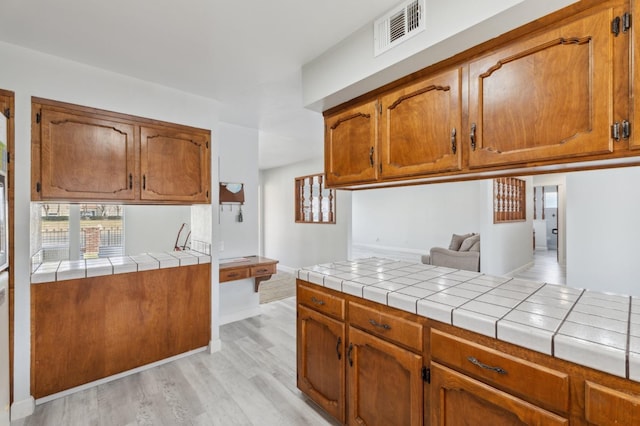 kitchen featuring tile countertops and light hardwood / wood-style floors