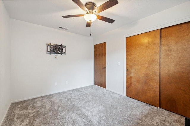 unfurnished bedroom featuring carpet floors, a closet, and ceiling fan