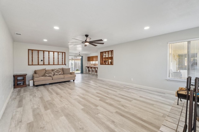 living room featuring ceiling fan and light hardwood / wood-style floors