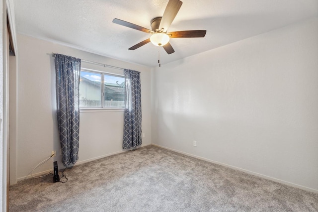 spare room featuring ceiling fan and carpet floors