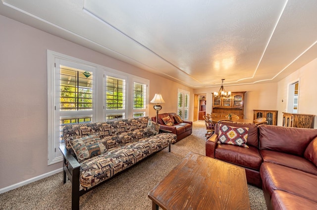 living room with a chandelier, carpet floors, and baseboards