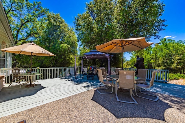 view of patio with outdoor dining space and a wooden deck