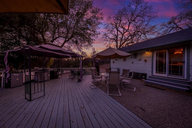 deck at dusk with entry steps and outdoor dining area