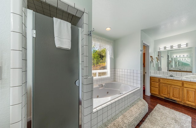 full bathroom featuring a tub with jets, wood finished floors, a shower stall, and vanity