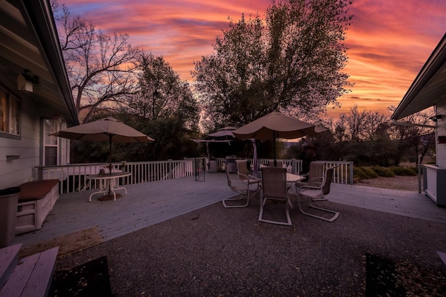 patio terrace at dusk featuring a deck and outdoor dining area