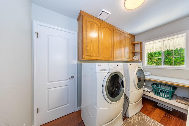 laundry room featuring cabinet space, visible vents, separate washer and dryer, and dark wood-type flooring