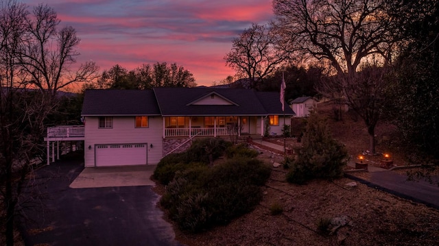 view of front of house with a garage, covered porch, and driveway