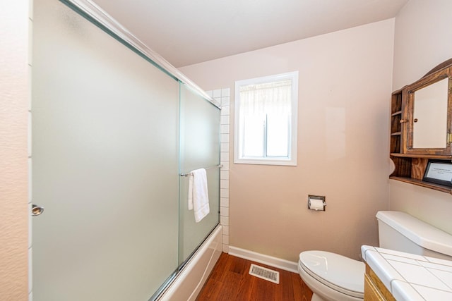 bathroom featuring baseboards, visible vents, toilet, wood finished floors, and vanity