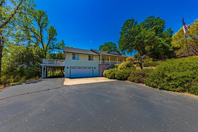 view of front of property with aphalt driveway, covered porch, a carport, and solar panels