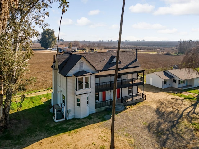 rear view of property featuring a yard and a rural view