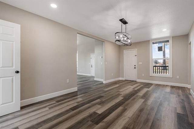 interior space with dark wood-type flooring and a chandelier