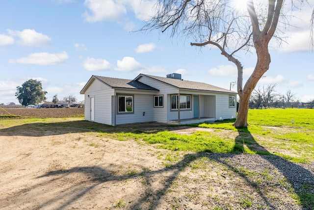 back of house with a lawn and a rural view