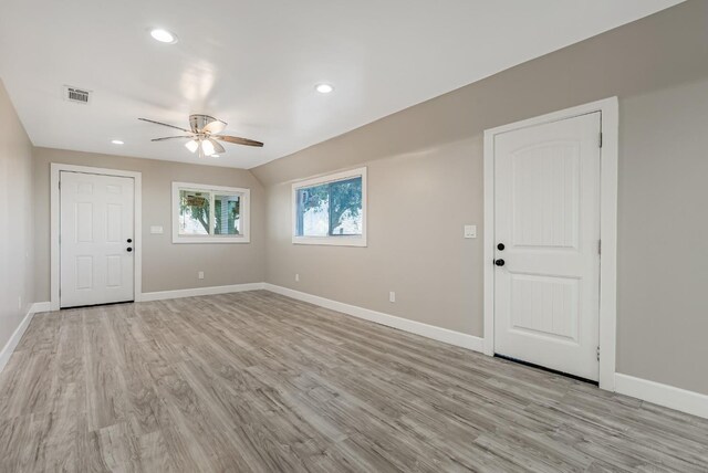 empty room with lofted ceiling, light hardwood / wood-style floors, and ceiling fan