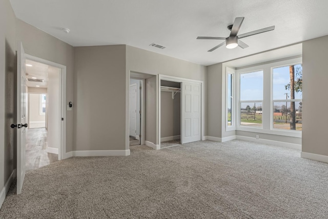 unfurnished bedroom with light colored carpet, ceiling fan, and a closet