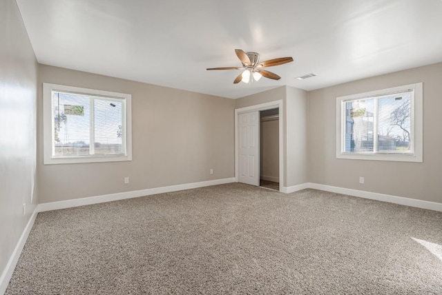 unfurnished bedroom featuring carpet, ceiling fan, and a closet