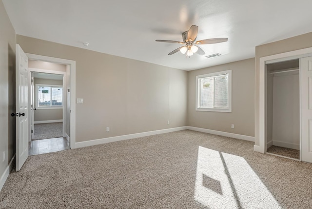 unfurnished bedroom with ceiling fan, light colored carpet, and a closet