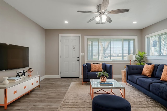 living room with light hardwood / wood-style flooring and ceiling fan