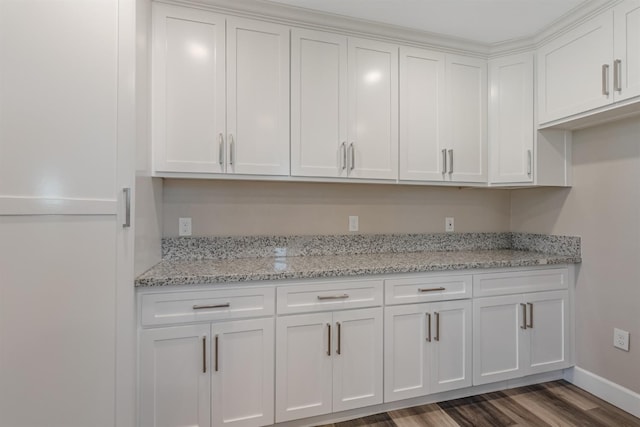 kitchen with light stone counters, dark hardwood / wood-style flooring, and white cabinets