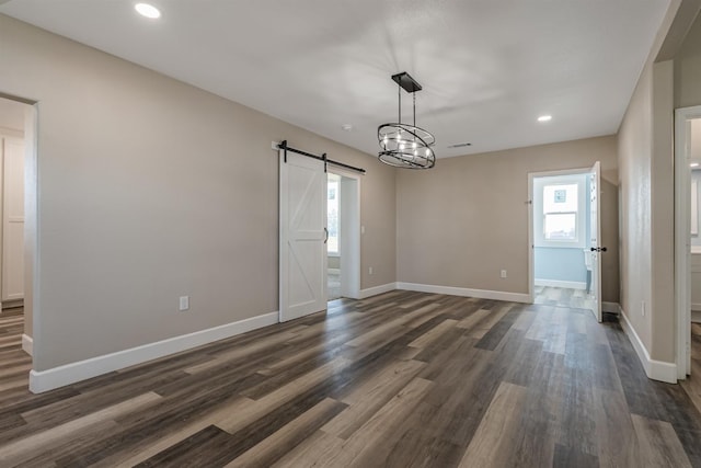 interior space featuring dark hardwood / wood-style floors, plenty of natural light, and a barn door