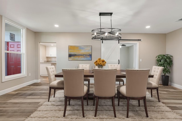 dining room featuring a barn door and light wood-type flooring