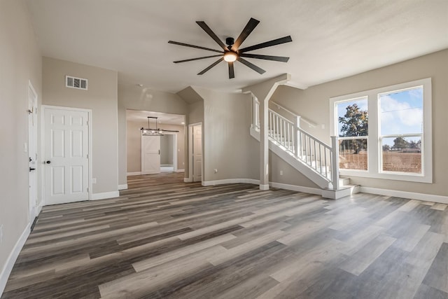 unfurnished living room featuring dark hardwood / wood-style floors and ceiling fan with notable chandelier