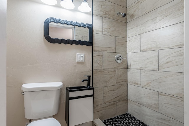 bathroom featuring a tile shower and toilet