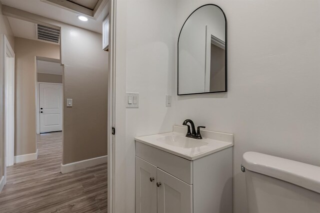 bathroom featuring vanity, hardwood / wood-style floors, and toilet