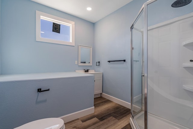 bathroom featuring toilet, hardwood / wood-style floors, vanity, and walk in shower