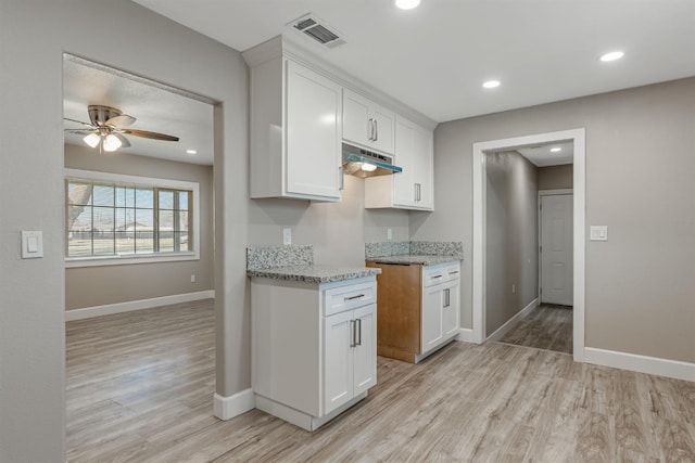 kitchen featuring white cabinetry, ceiling fan, light stone countertops, and light hardwood / wood-style floors