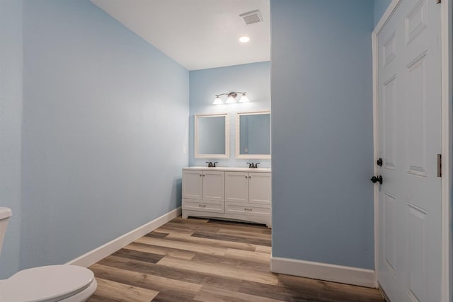 bathroom featuring vanity, hardwood / wood-style floors, and toilet