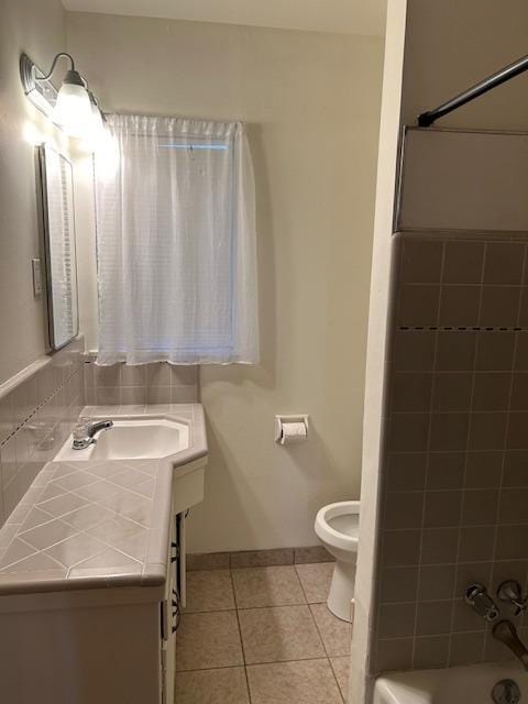 full bath featuring shower / washtub combination, toilet, vanity, tile patterned flooring, and baseboards