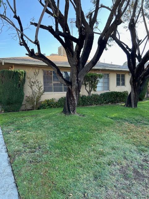 view of side of property with a yard and stucco siding