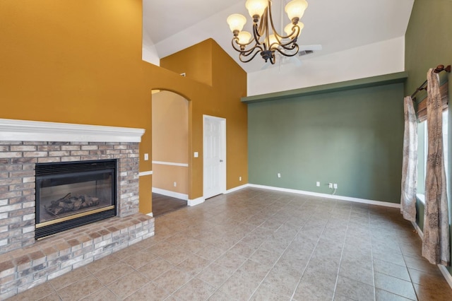 unfurnished living room with a notable chandelier, a fireplace, tile patterned floors, and high vaulted ceiling