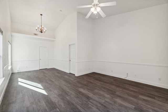 empty room featuring dark wood-type flooring, ceiling fan with notable chandelier, and high vaulted ceiling